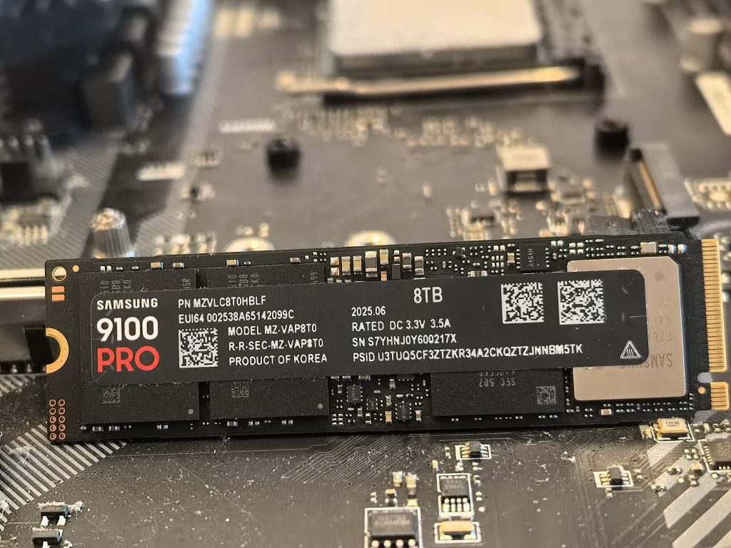 Samsung 9100 Pro 8 TB je dvostranski M.2 NVMe SSD. Na fotografiji je sprednja stran pogona s Samsungovim krmilnikom »Presto«, DRAM pomnilnikom in dvojnim nizom NAND čipov.